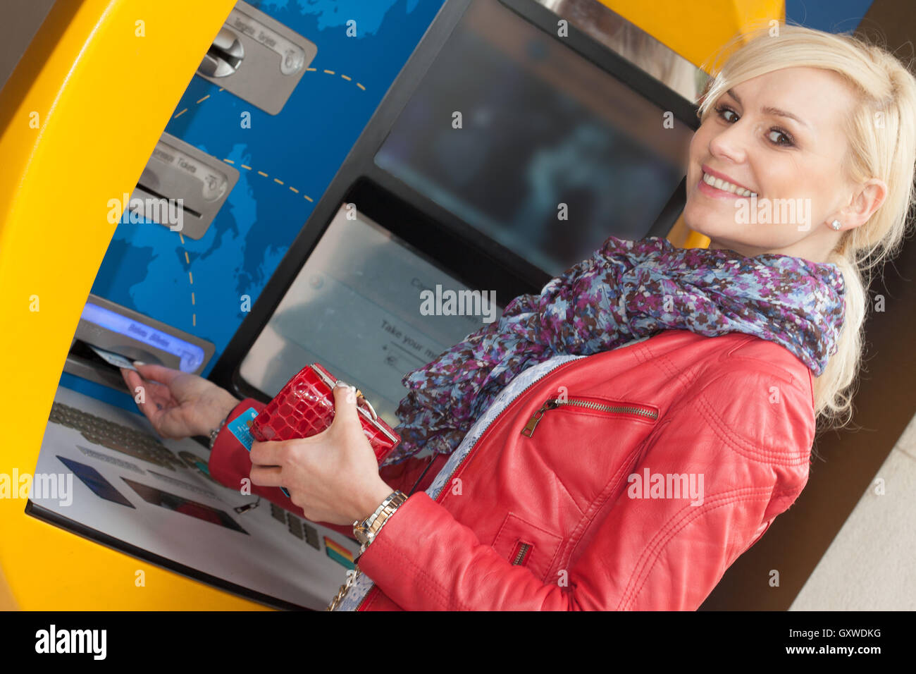 Wunderschöne lächelnde Frau mit einer Bank ATM Stockfoto