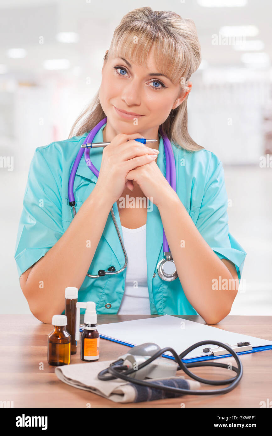 eine Frindly Ärztin am Tisch Stockfoto