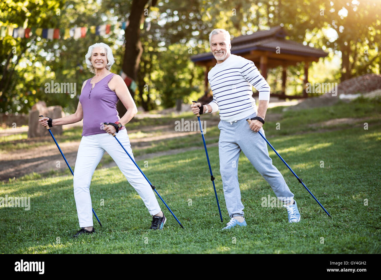 Zwei ältere Menschen darstellende Übungen mit tracking-sticks Stockfoto