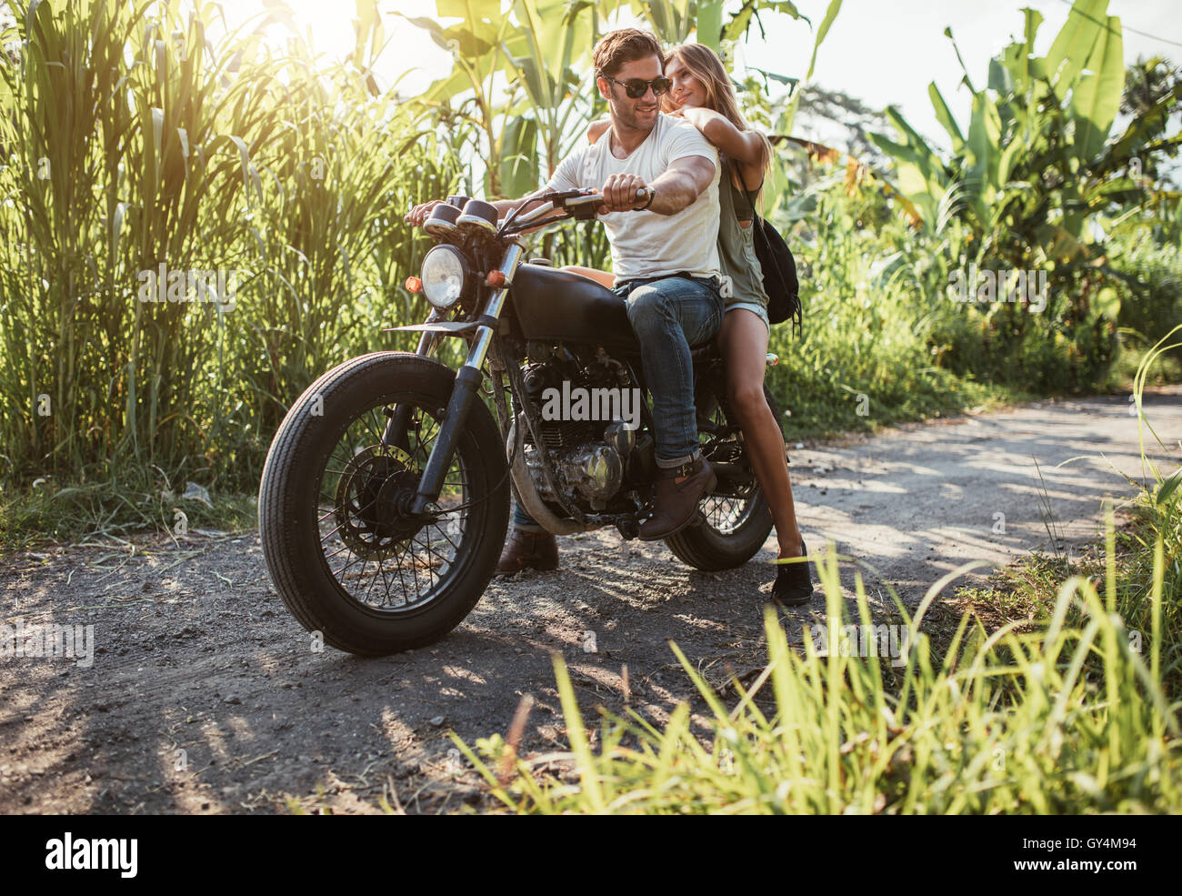 Mann mit ihrer Freundin auf dem Motorrad. Junges Paar gebietsübergreifenden Motorrad auf Landstraße. Stockfoto