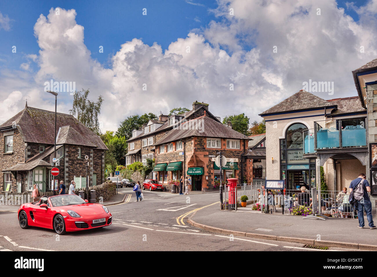 Ein roter Sportwagen fahren durch das Dorf von Ambleside, Nationalpark Lake District, Cumbria, England, UK Stockfoto