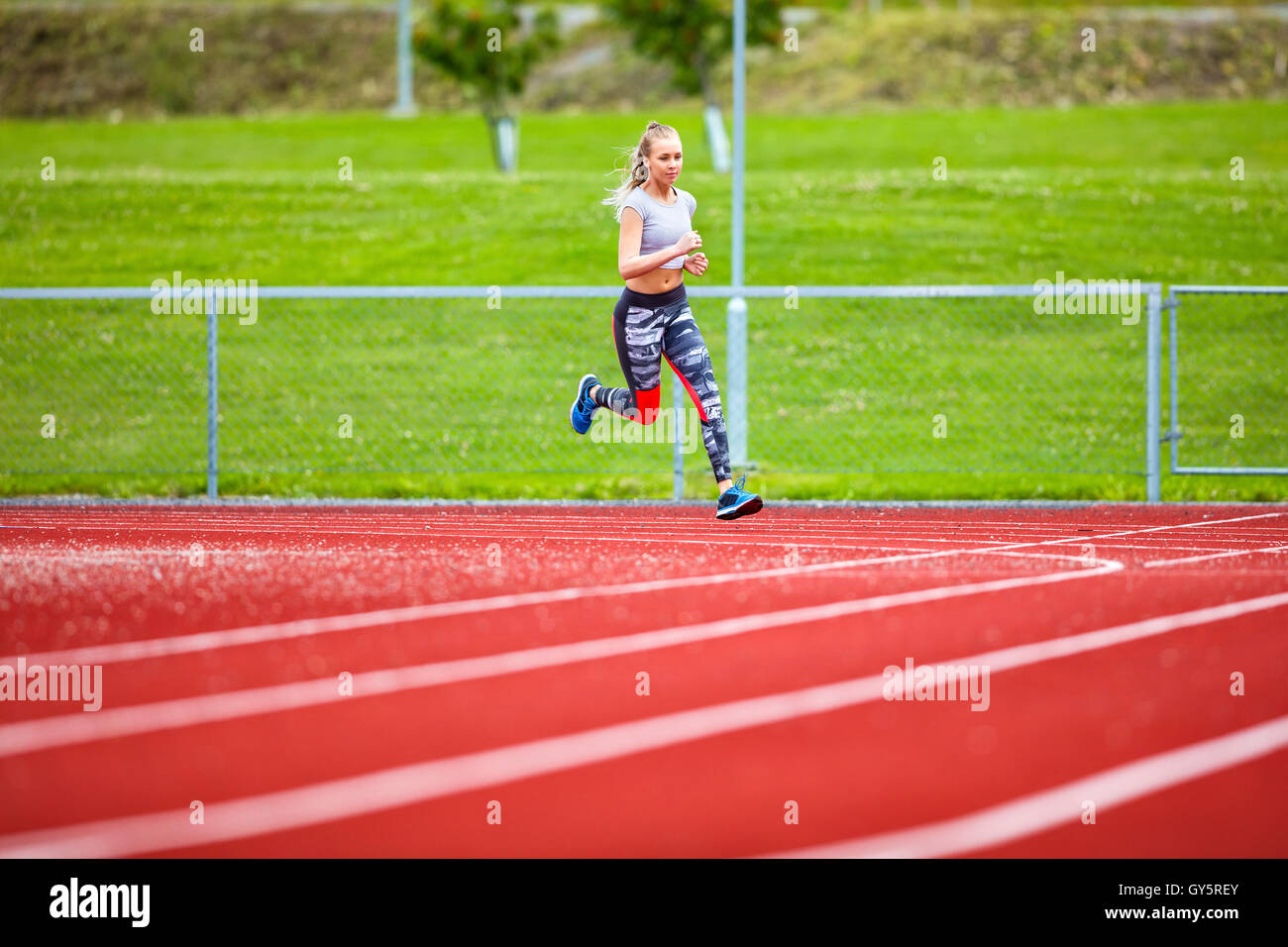 Junge Frau läuft auf Sport Tracks bestimmt Stockfoto