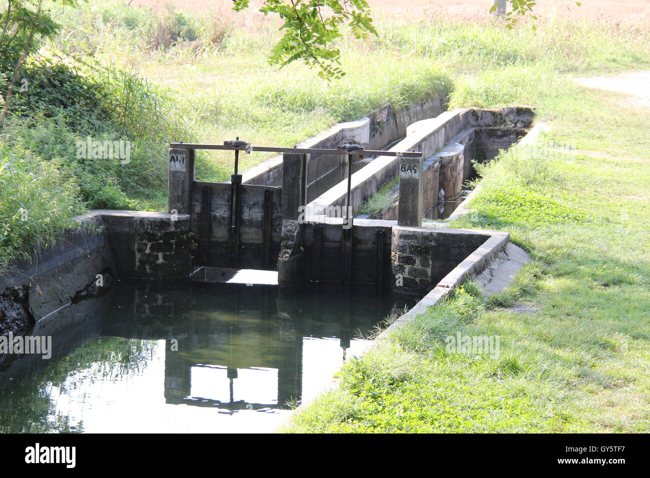 Bewässerung-Kanal mit fließendem Wasser in Nord-Italien, Lombardei, Canal Villoresi, Headgates, Hebezeuge. Stockfoto