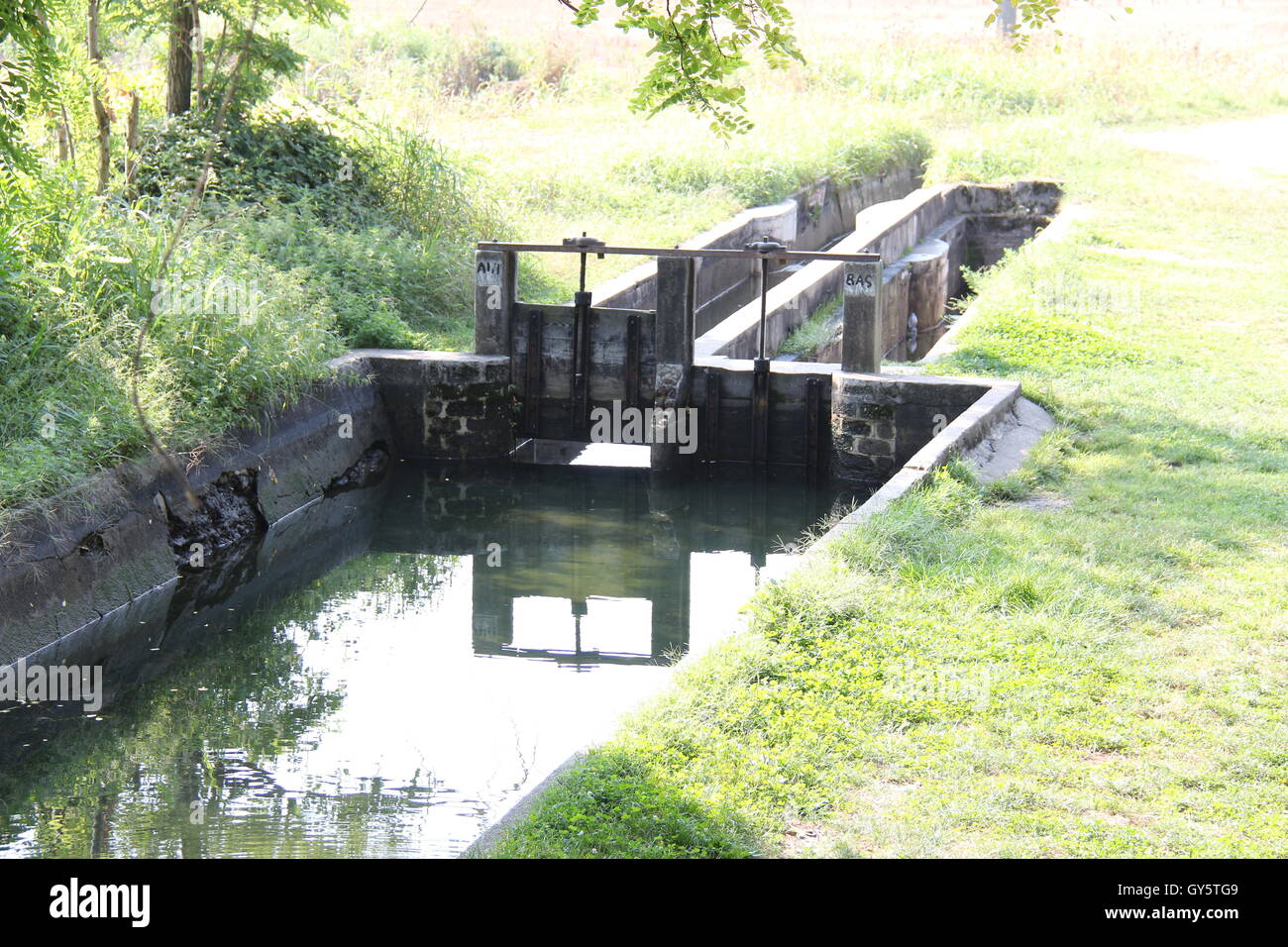 Bewässerung-Kanal mit fließendem Wasser in Nord-Italien, Lombardei, Canal Villoresi, Headgates, Hebezeuge. Stockfoto