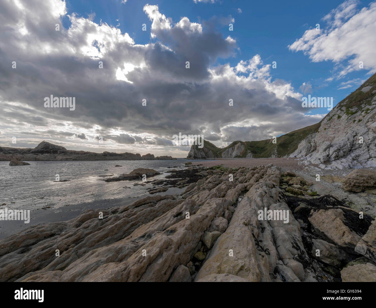 Landschaft, die felsige Küste der Mann O'War Strand an einem feinen Sommertag mit Durdle Door Landzunge im Hintergrund darstellen. Stockfoto