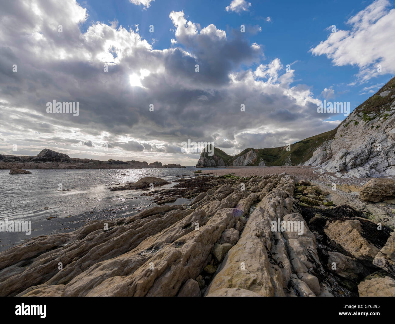Landschaft, die felsige Küste der Mann O'War Strand an einem feinen Sommertag mit Durdle Door Landzunge im Hintergrund darstellen. Stockfoto