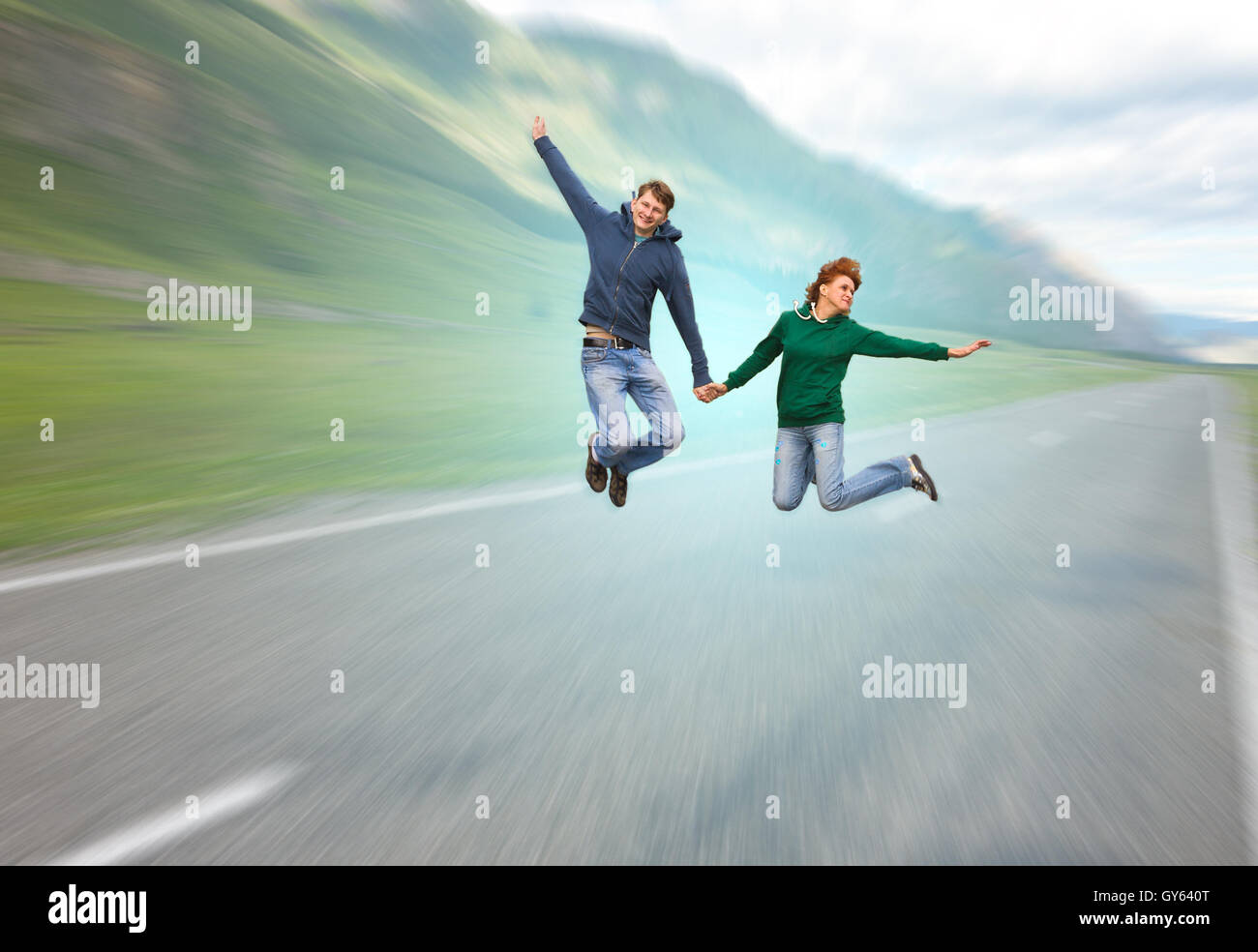 Junge romantische Brautpaar (kaukasischer Mann und Frau), Spaß und magische Abenteuer Flyuing über asphaltierte Straße Stockfoto
