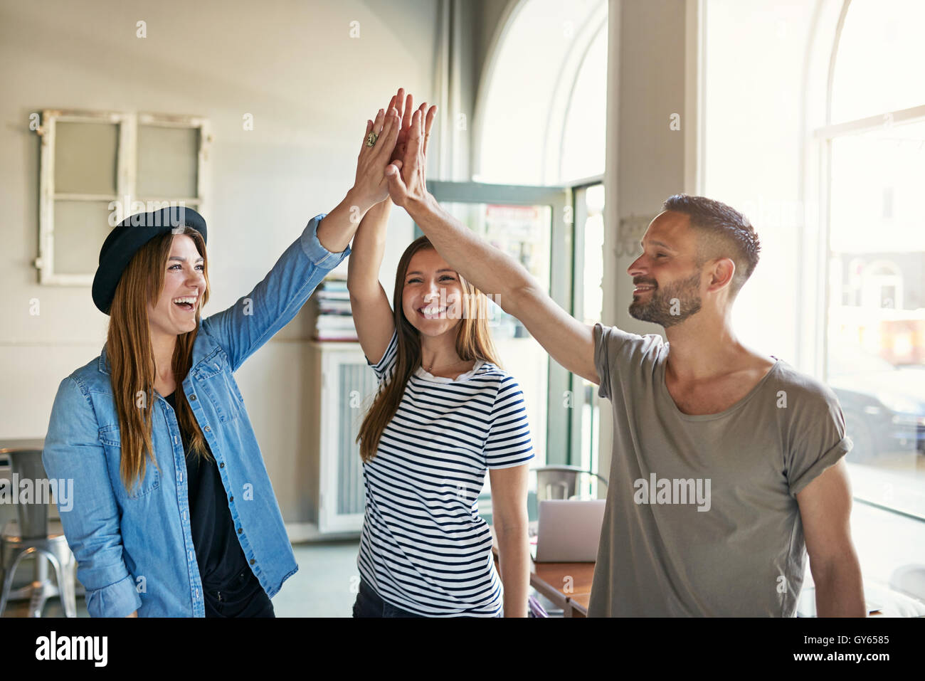Glücklich begeisterte Geschäftspartner dabei eine hohe Fives Geste, wie sie einen Erfolg im Büro, trendige junge moderne g feiern Stockfoto