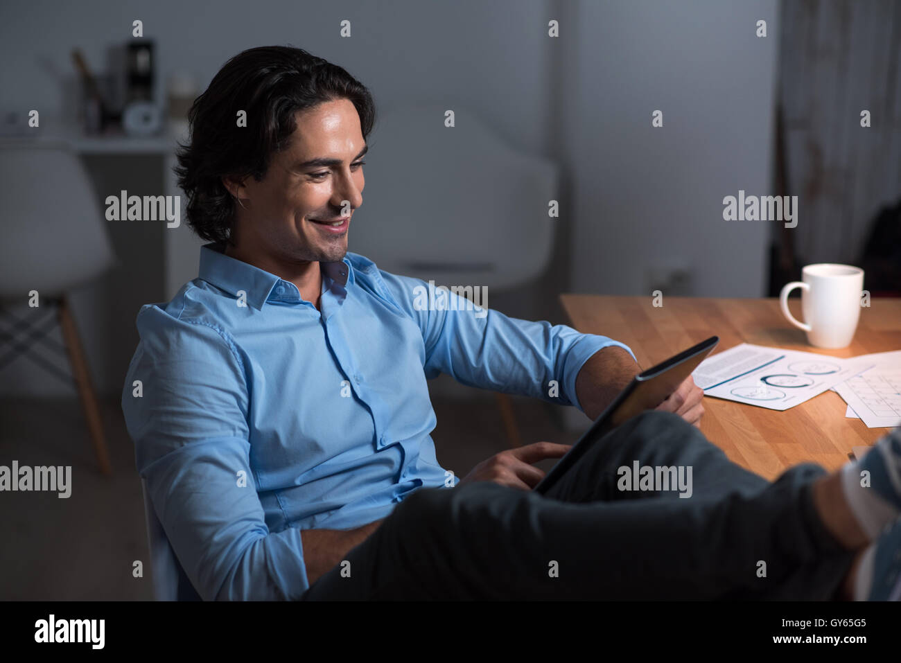 Lächelnde entspannte jungen Mann mit Tablet. Stockfoto