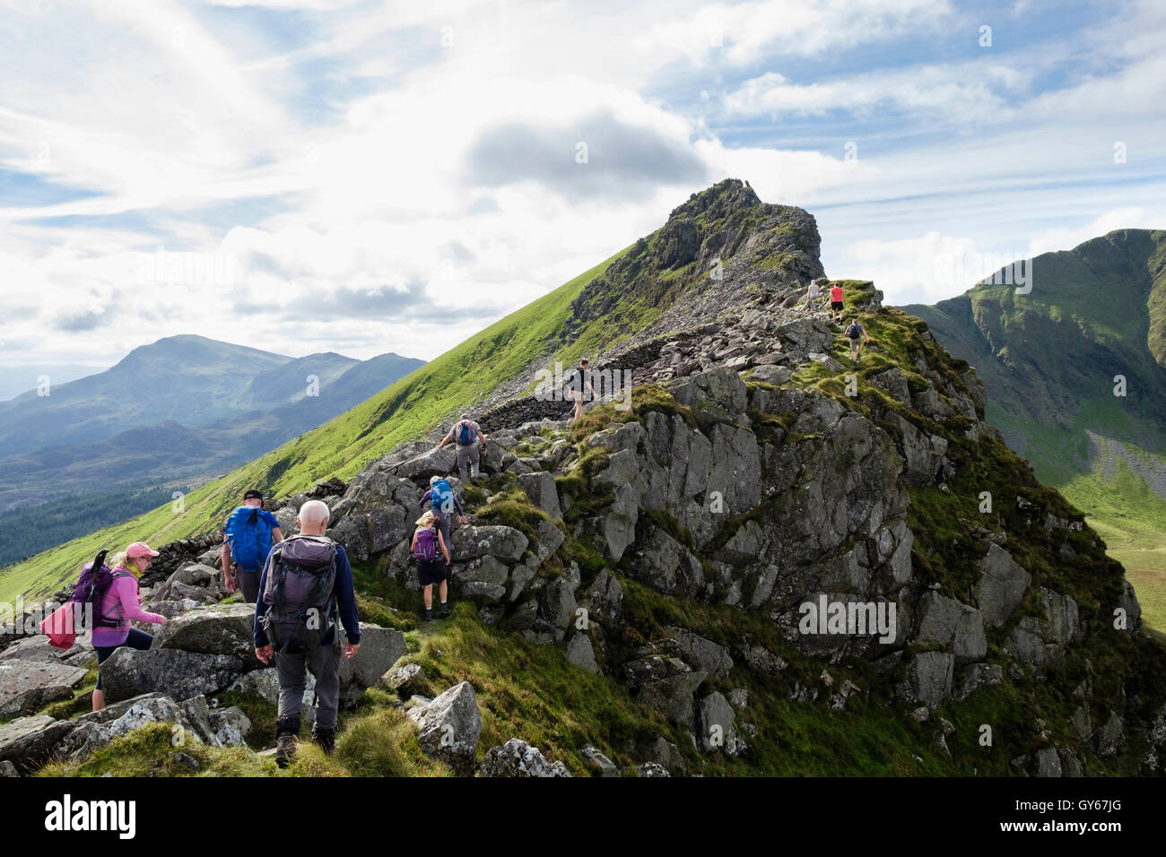 Wanderer, Klettern über die Felsen Mynydd Drws-y-Coed auf Nantlle Grat wandern in Berge von Snowdonia-Nationalpark. North Wales, UK Stockfoto