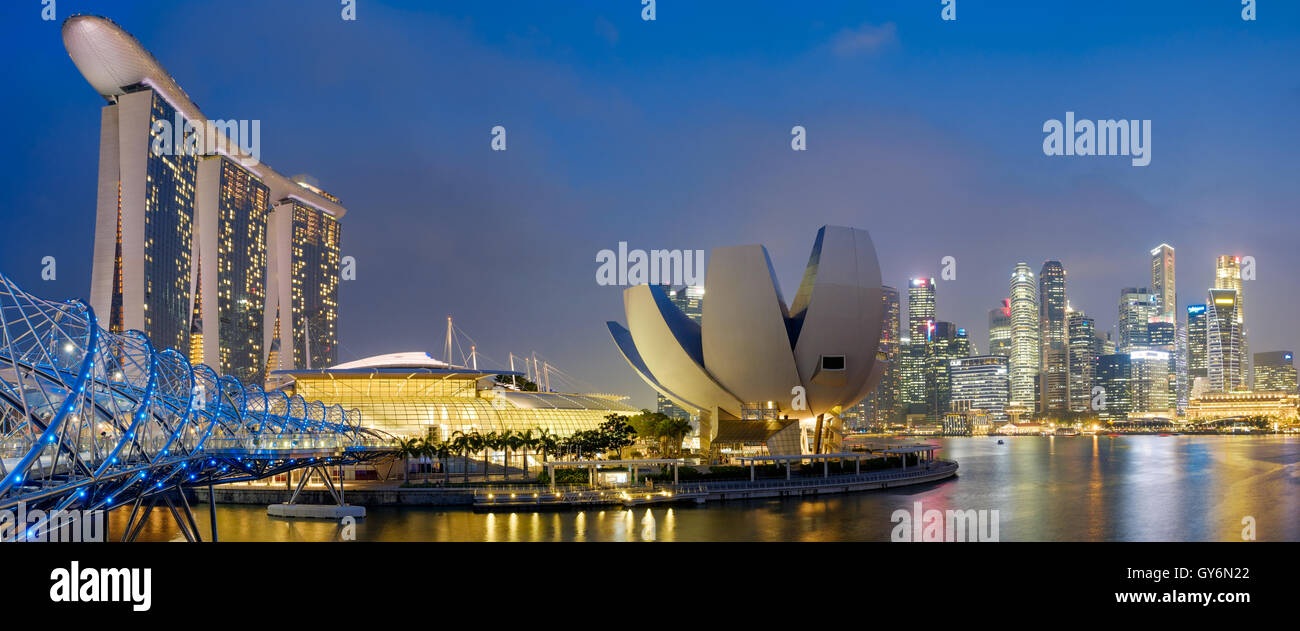 Panoramablick auf den Yachthafen in Singapur mit der Marina Bay Sands und Helix Bridge in der Dämmerung Stockfoto