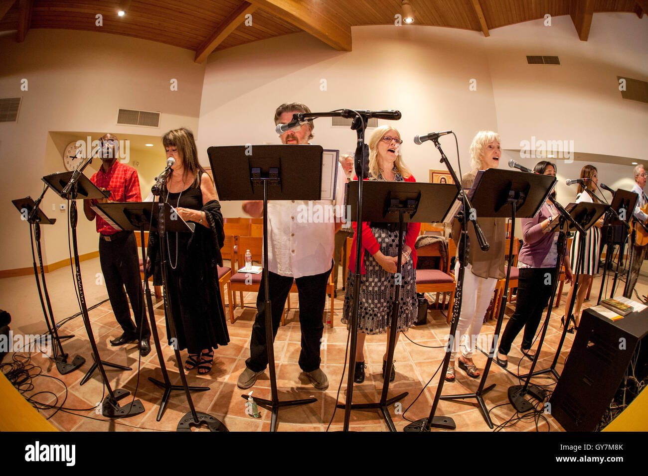 Ein Vielvölkerstaat Chor singt eine Hymne während der Messe in einer Laguna Niguel, CA, katholische Kirche. Hinweis: Notenständer und Mikrofone. Stockfoto