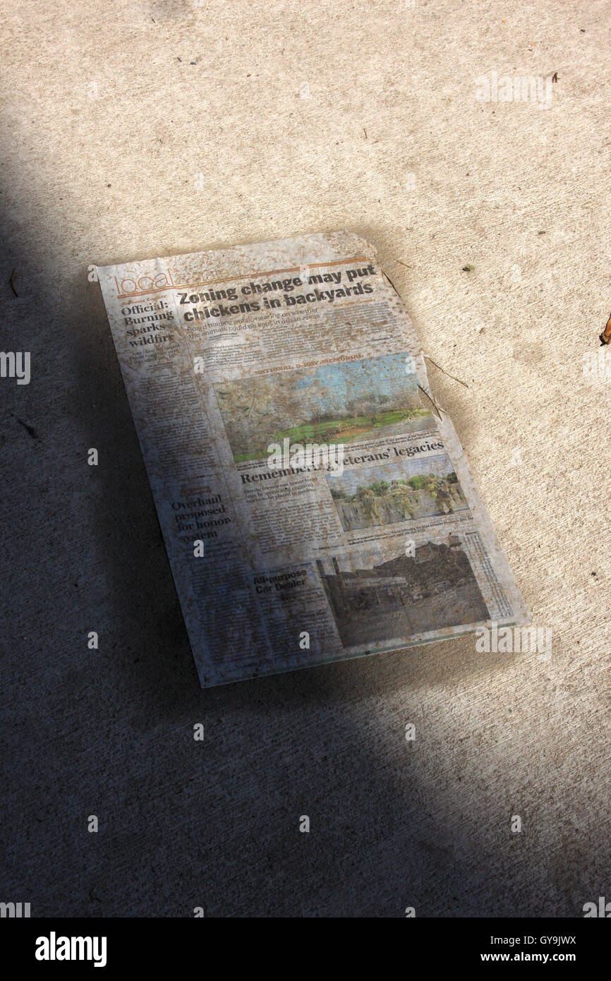 Zeitungsseite auf Bürgersteig Stockfoto