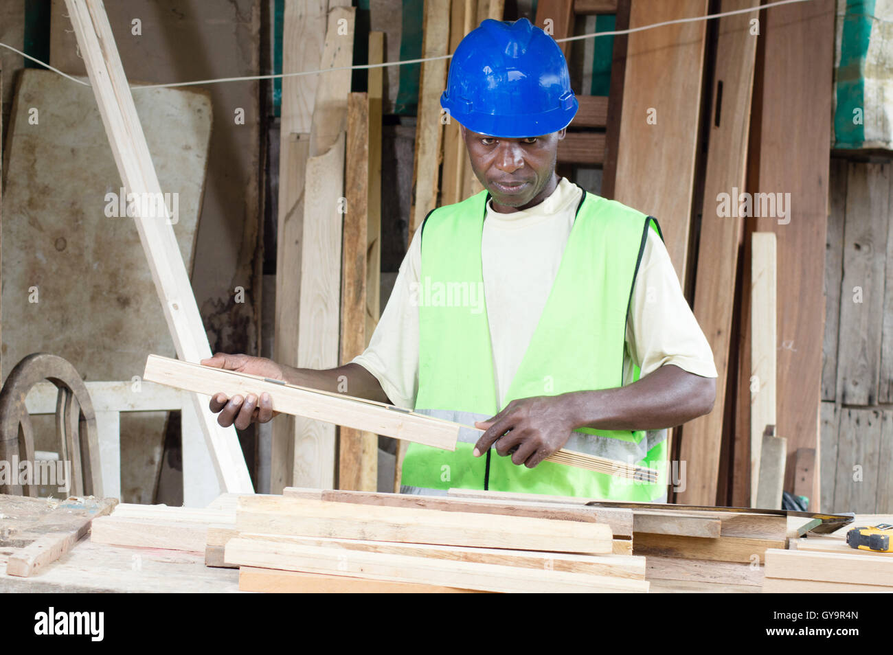 Dieser Schreiner nimmt das Maß seiner Platten haben eine einheitliche Höhe von seiner Tabellen. Stockfoto