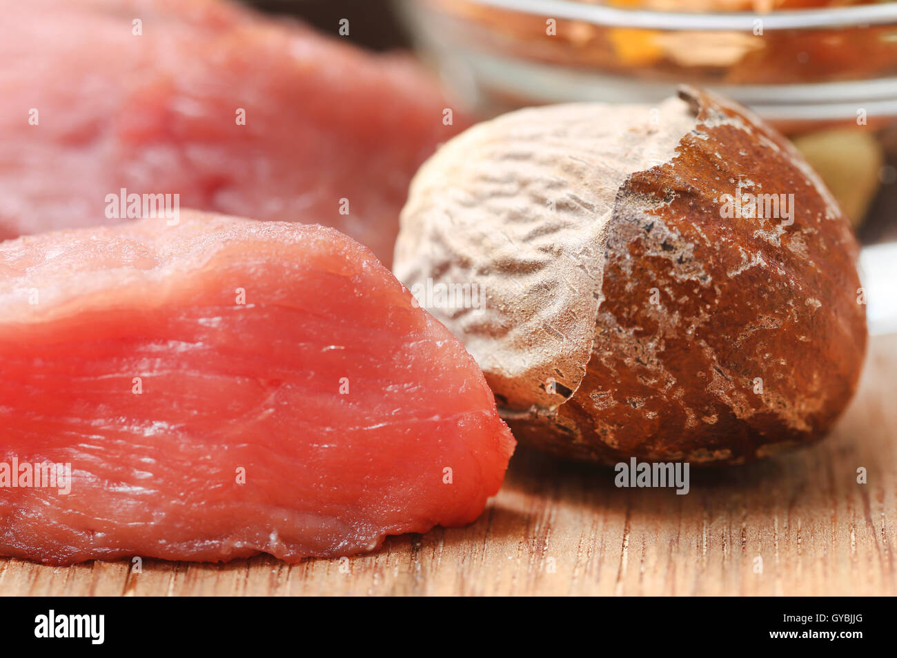 Rohes Rindfleisch mit Muskatnuss auf Holzuntergrund Stockfoto