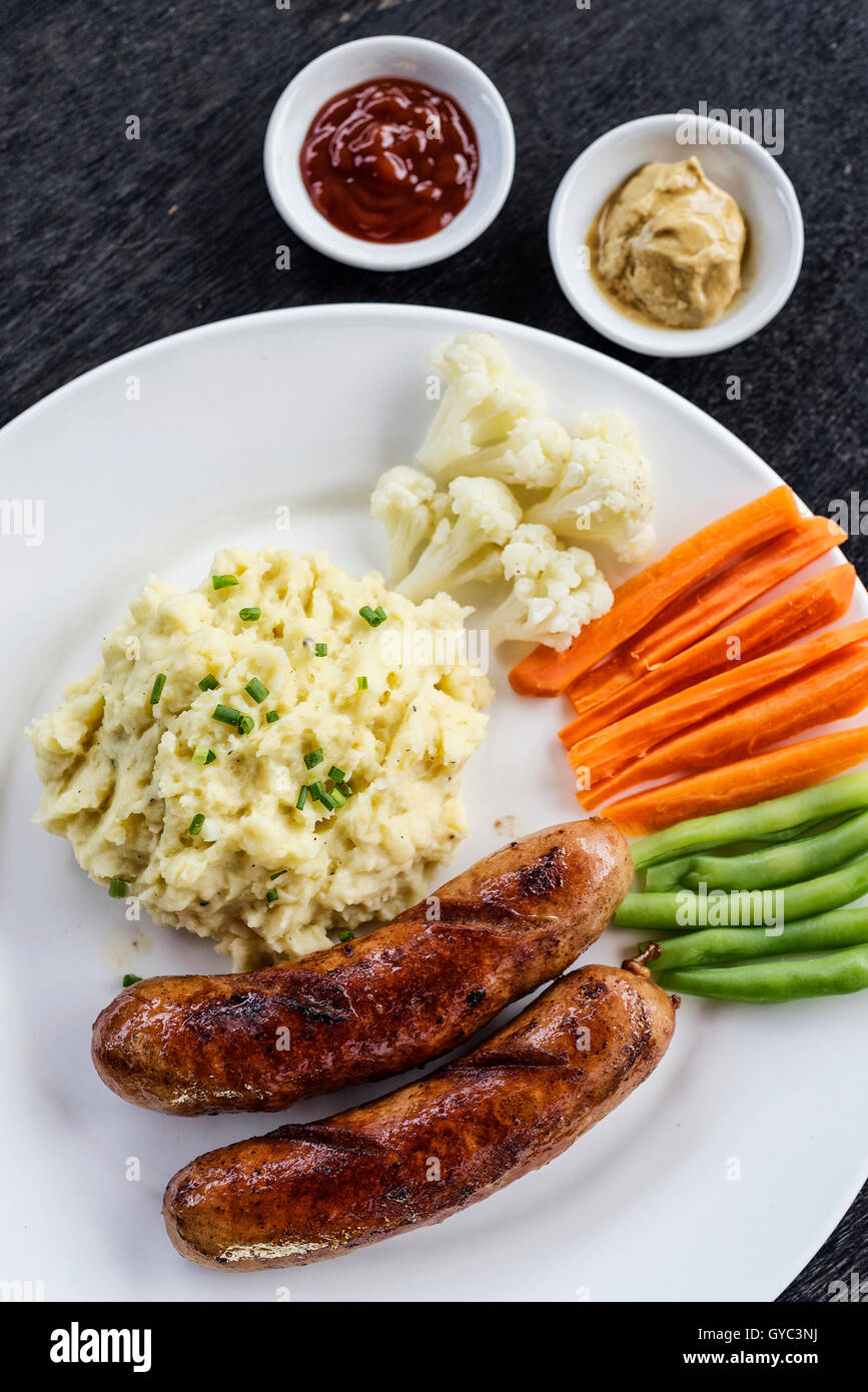 Deutsche Bratwurst mit gestampften Kartoffeln und Gemüse einfache Mahlzeit Stockfoto