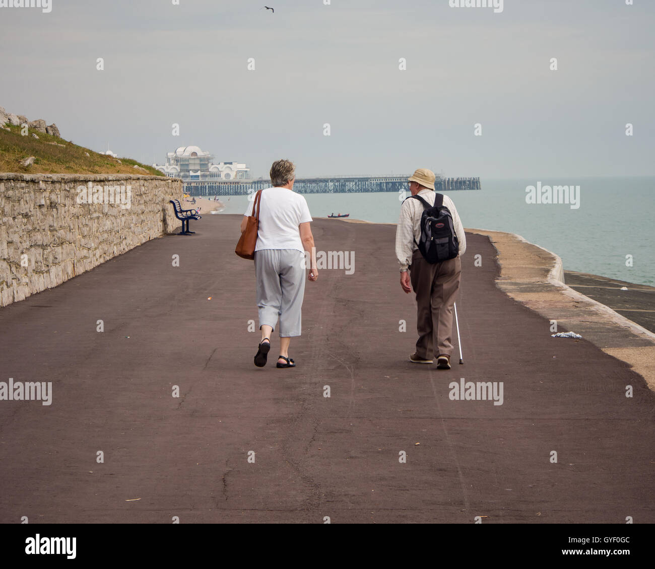 Ein älteres paar zu Fuß entlang einer einsamen Southsea Seafront Stockfoto