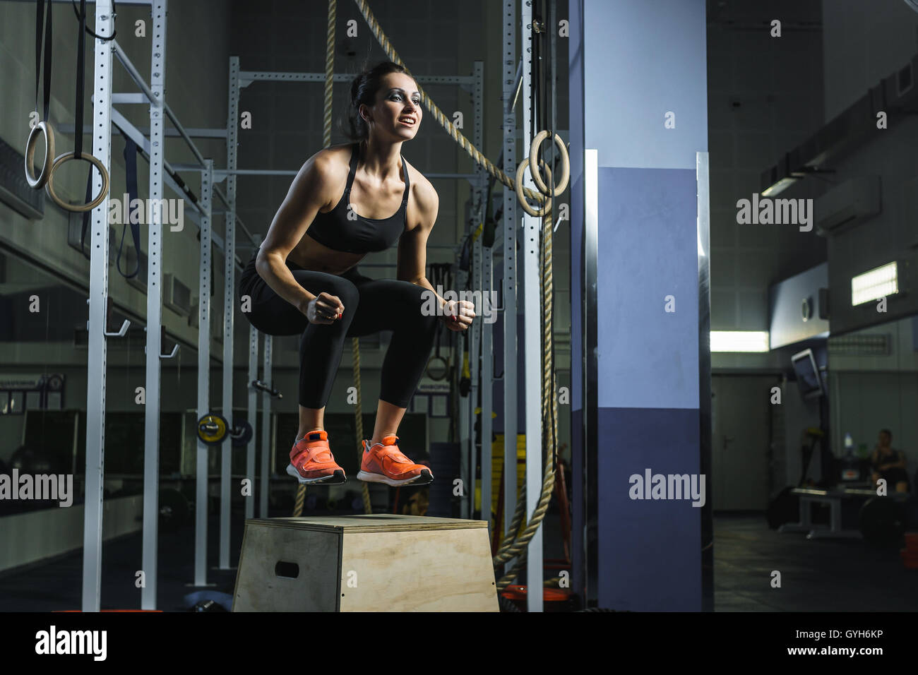 Konzept: Kraft, Stärke, Gesundheit, Sport. Leistungsstarke attraktive muskulöse Frau CrossFit Trainer tun Sprünge während des Trainings Stockfoto