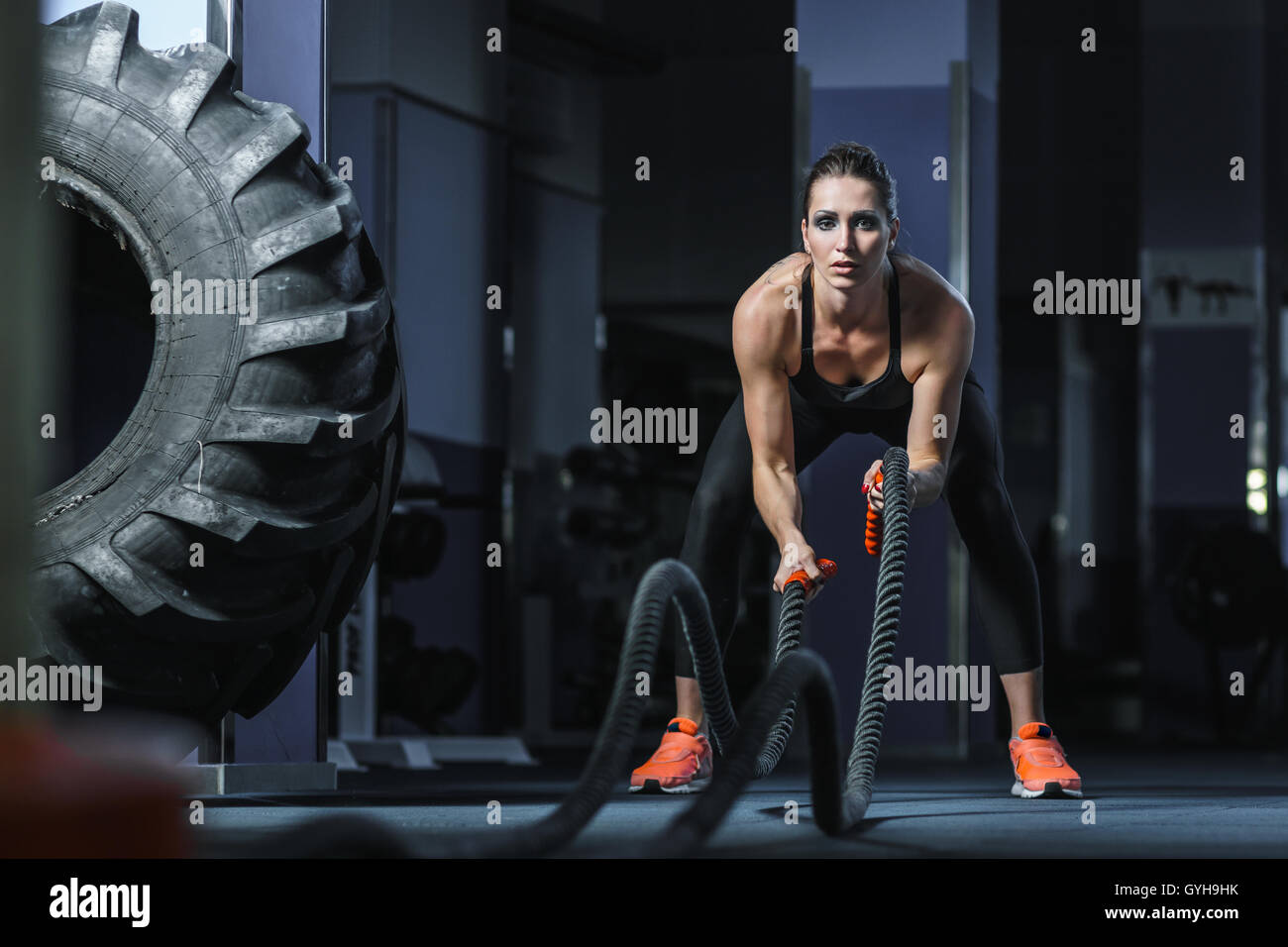 Konzept: Kraft, Stärke, Gesundheit, Sport. Leistungsstarke attraktive muskulöse Frau CrossFit Trainer kämpfen Training mit r Stockfoto