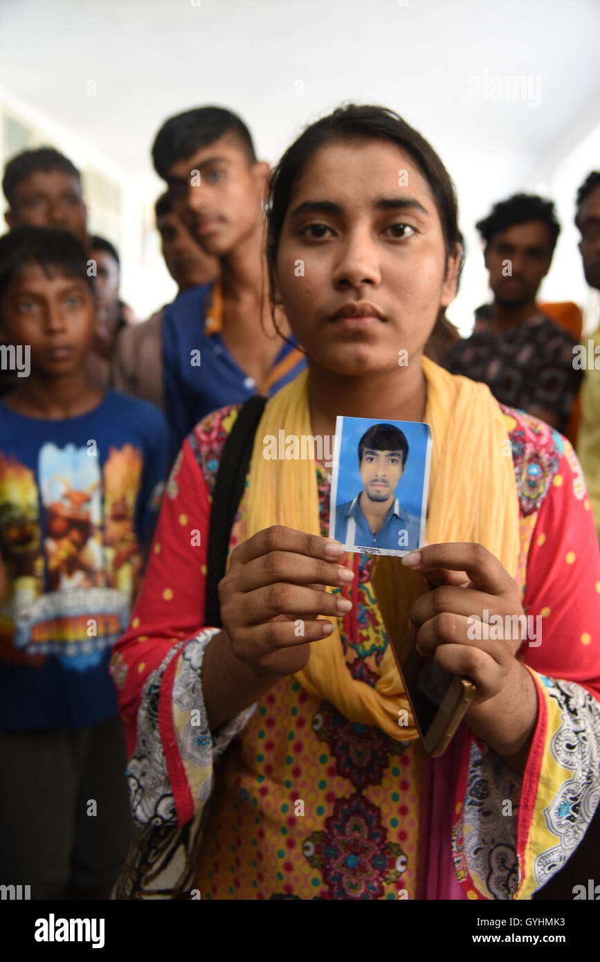 Verwandter von Fabrikarbeiterin aus Bangladesch hält sein Bild in einem Gebäude, wo ihre Körper waren brachte nach einer Explosion ich Stockfoto