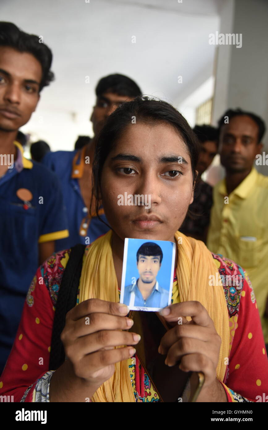 Verwandter von Fabrikarbeiterin aus Bangladesch hält sein Bild in einem Gebäude, wo ihre Körper nach einer Explosion gebracht wurden Stockfoto