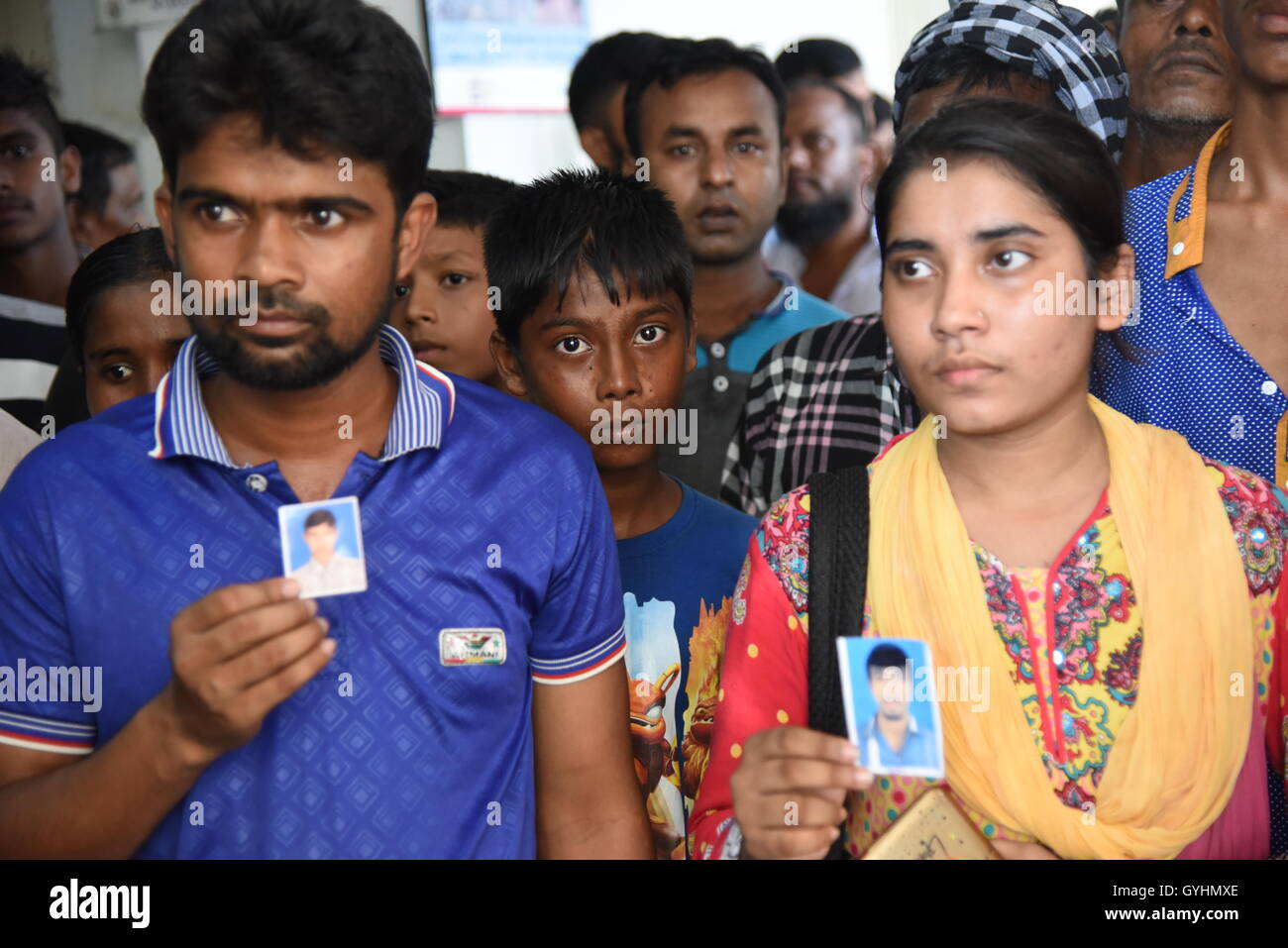 Verwandter von Fabrikarbeiterin aus Bangladesch hält sein Bild in einem Gebäude, wo ihre Körper nach einer Explosion gebracht wurden Stockfoto