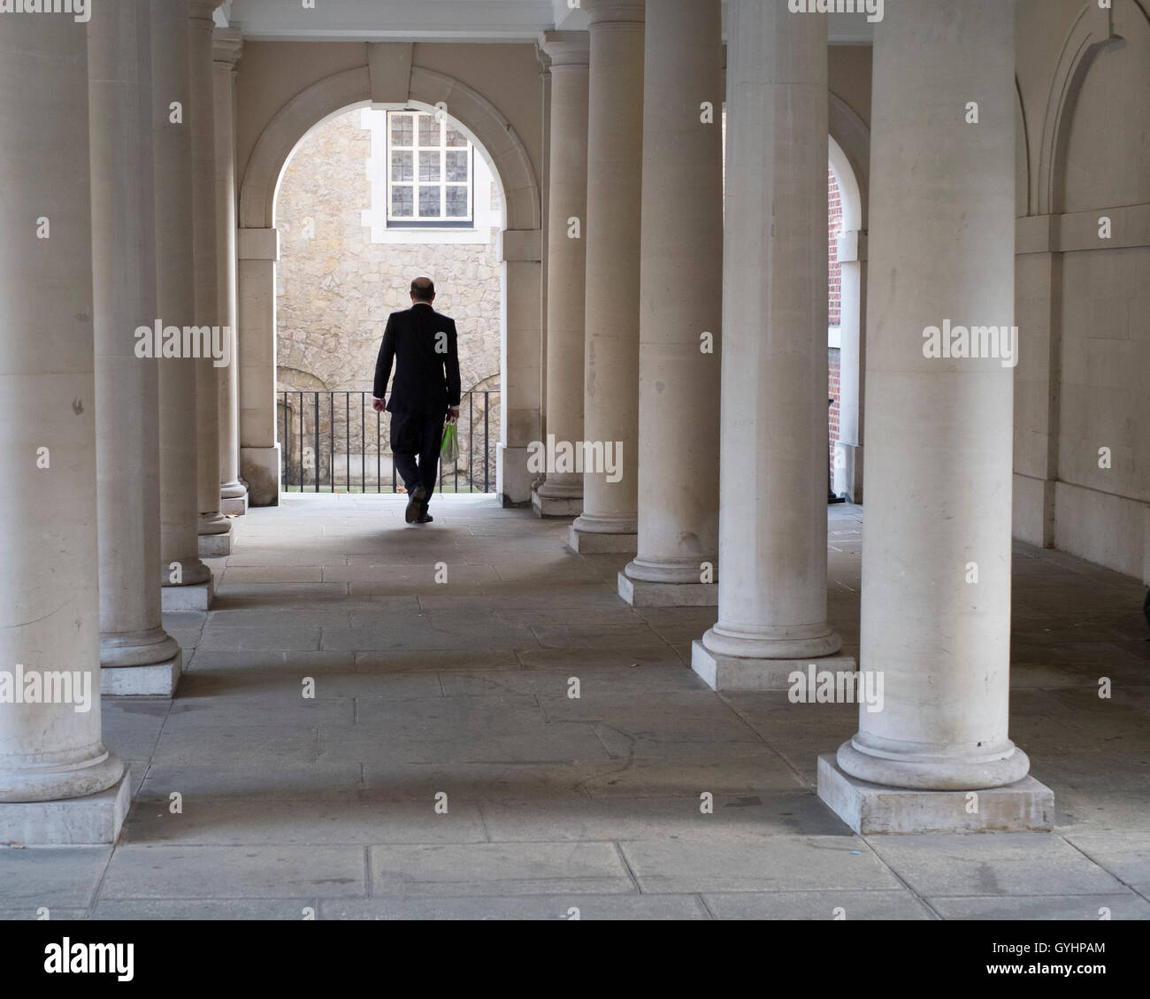 Mann zu Fuß durch Säulen der klassischen Stil Gebäude Stockfoto
