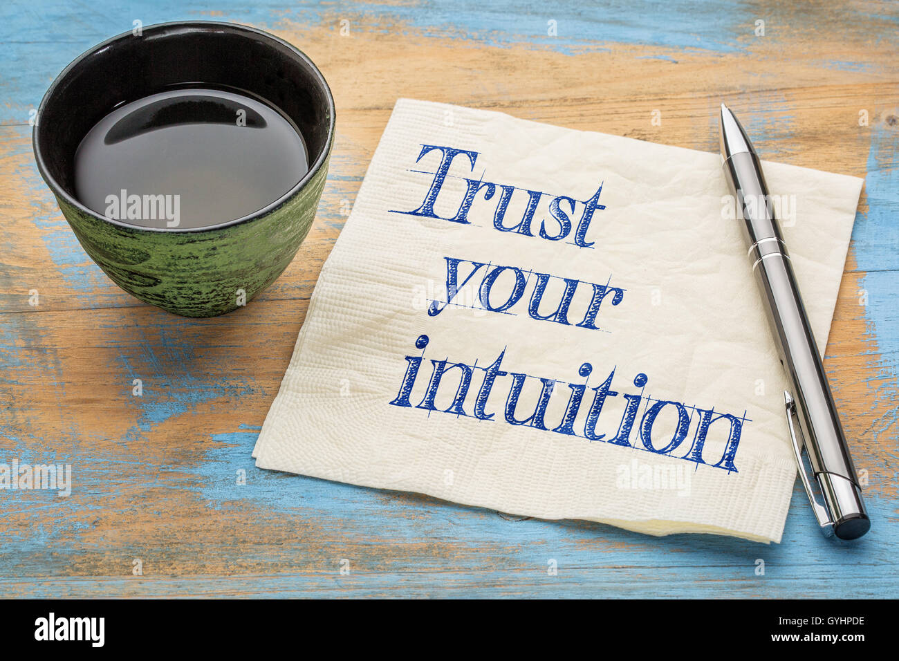 Vertrauen Sie Ihrer Intuition Erinnerung - Handschrift auf einer Serviette mit einer Tasse Tee Stockfoto