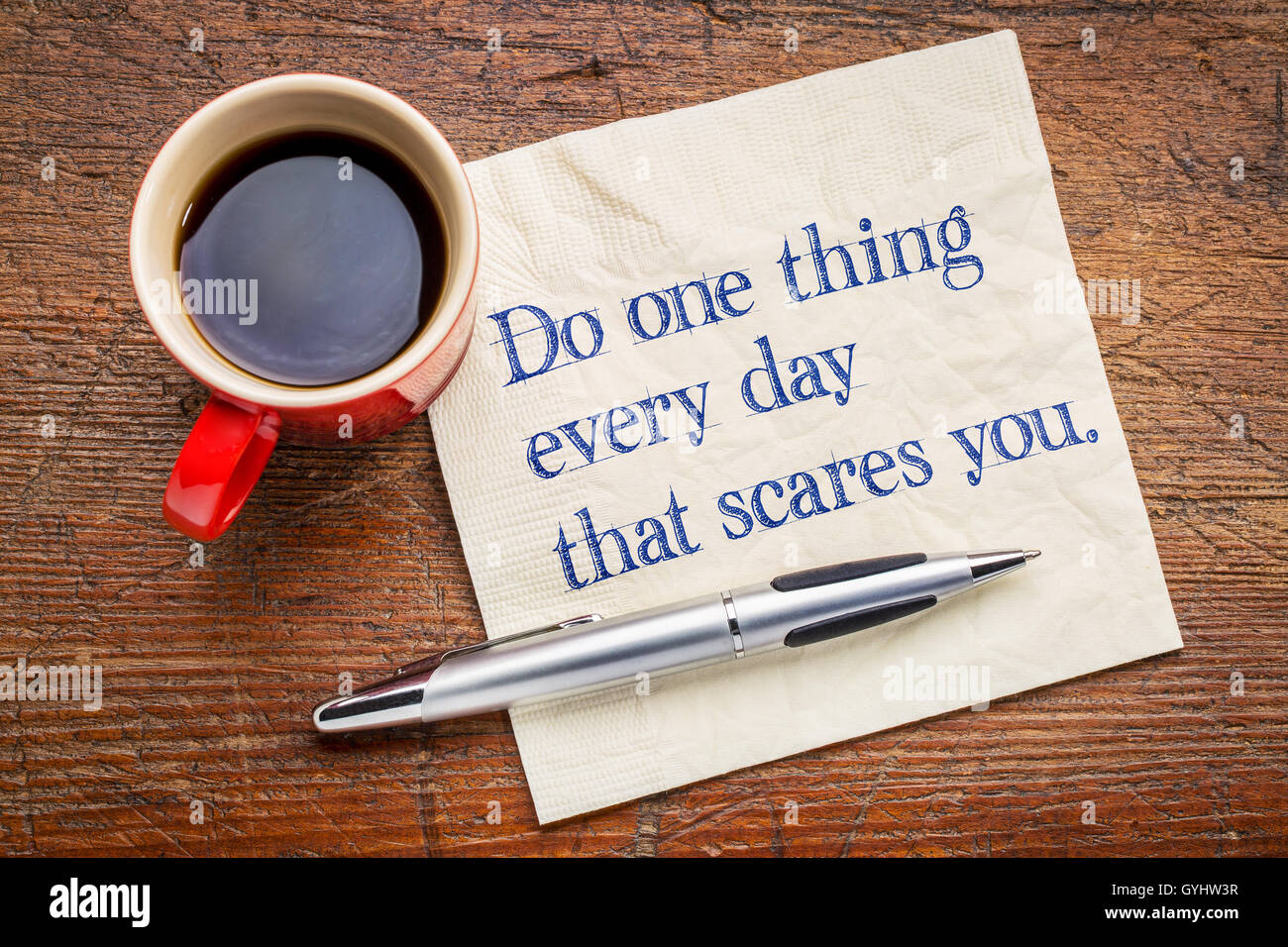 Eins tun jeden Tag, das schreckt Sie - motivierende Handschrift auf einer Serviette mit einer Tasse Kaffee Stockfoto