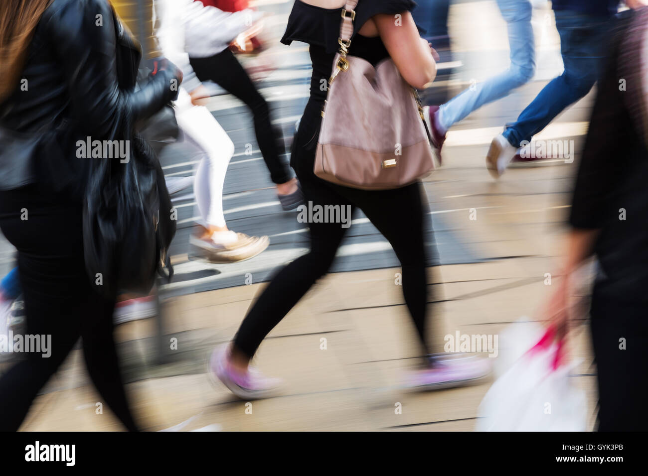 Menschen in Bewegung gezeigt blur überqueren einer Straße in der Stadt Stockfoto