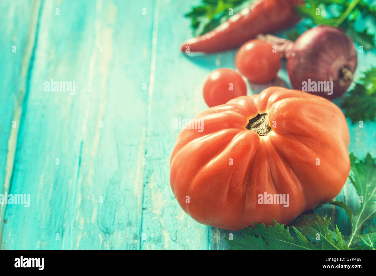 Tomaten und anderes Gemüse auf hellem Cyan Hintergrund Stockfoto