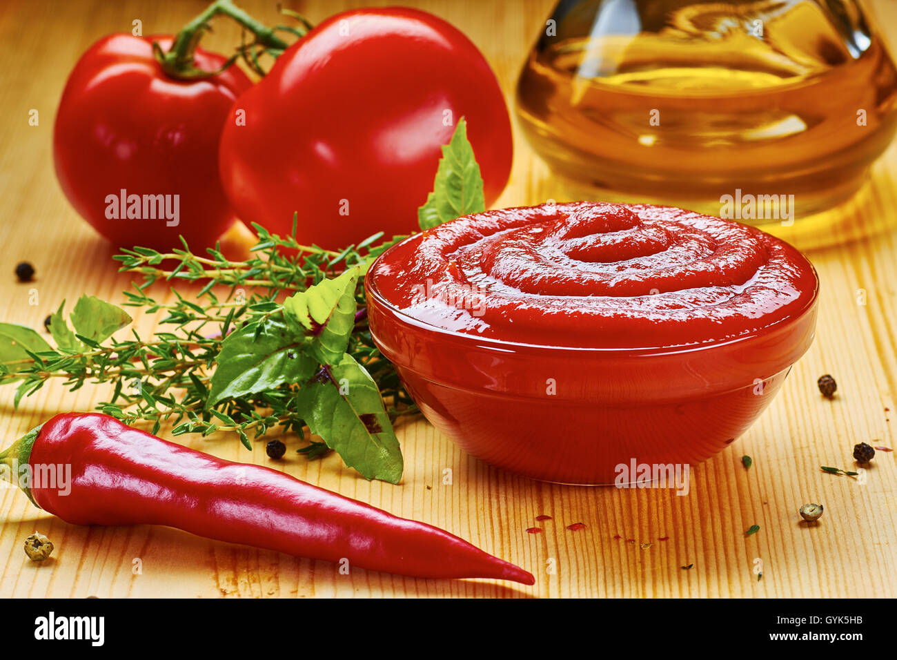 Schüssel mit Tomatensauce und Zutaten auf Holztisch Stockfoto