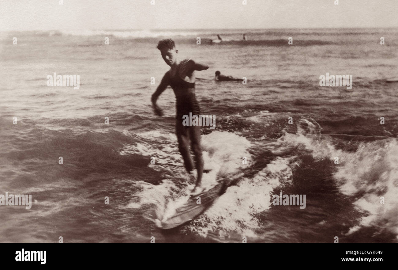 Surfer reiten hölzernen Surfbrett im Waikiki, Honolulu, Hawaii-c1920s. Stockfoto