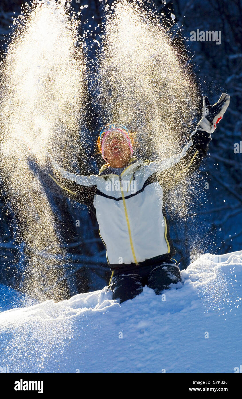 Frau werfen Schnee bis in die Luft, Frankreich Stockfoto