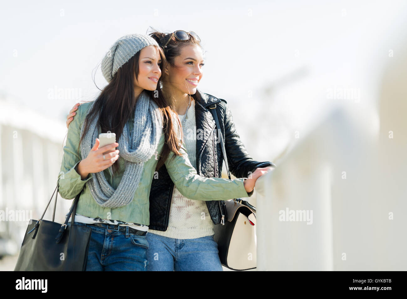 Zwei junge und schöne Frauen auf der Suche über einen Dock-Zaun Stockfoto