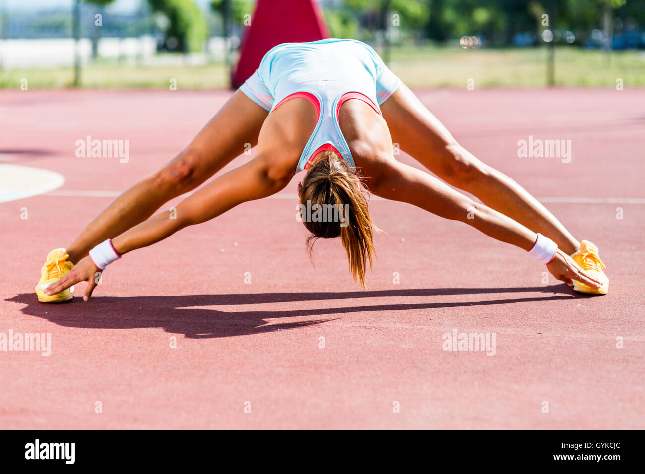 Schöne junge sportliche Frau erstreckt sich im Sommer vor der Ausführung Stockfoto