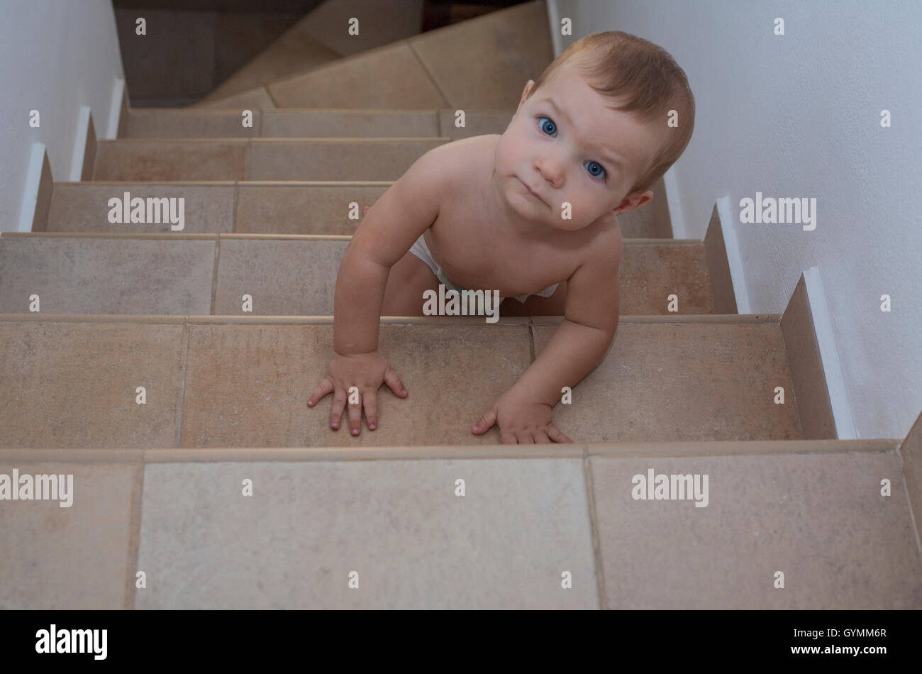 Baby Junge die Treppe hinauf kriechen. Erhöhte Ansicht Stockfoto