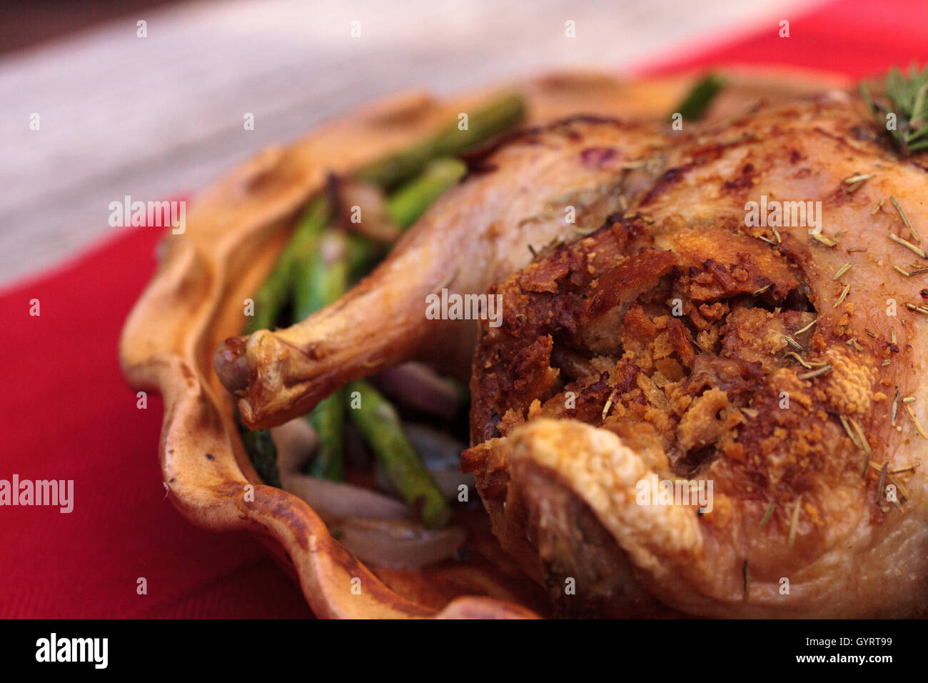 Rosmarin gebratene Ente gefüllt mit Brot Füllung und beringt mit Spargel in einer Keramik-Schale während der Ferienzeit. Stockfoto