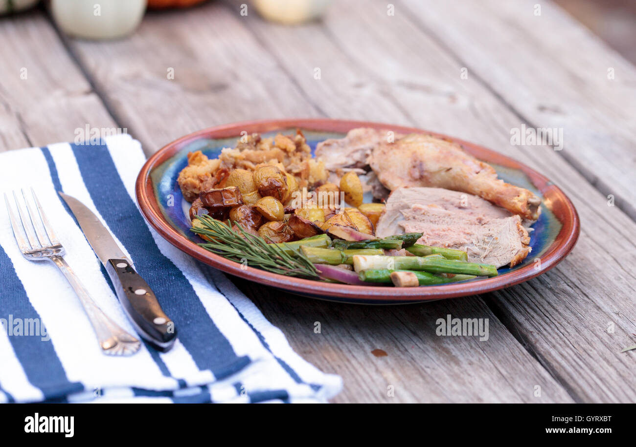 Rosmarin gebratene Ente gefüllt mit Brot Füllung und beringt mit Spargel in einer Keramik-Schale während der Ferienzeit. Stockfoto