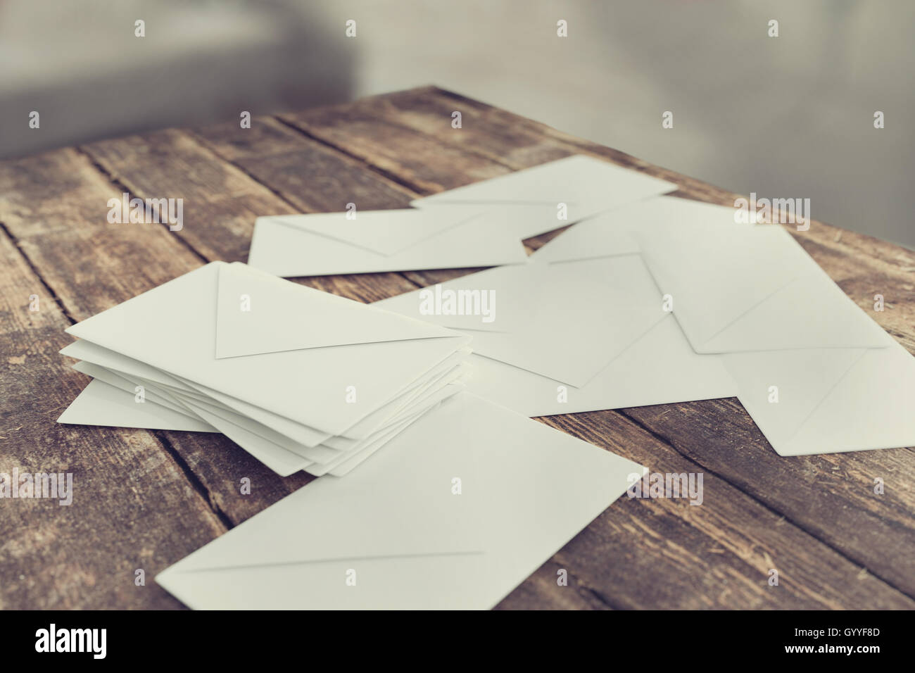 Briefumschläge für Post-Porto auf Holztisch Stockfoto
