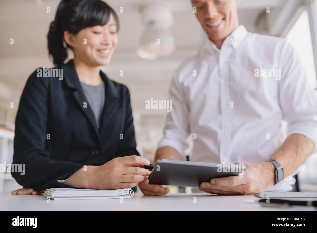 Kaufmann und Kauffrau mit Touchscreen-Computer im Büro. Junge Geschäftsleute, die gemeinsam mit weiblichen zeigt Stockfoto