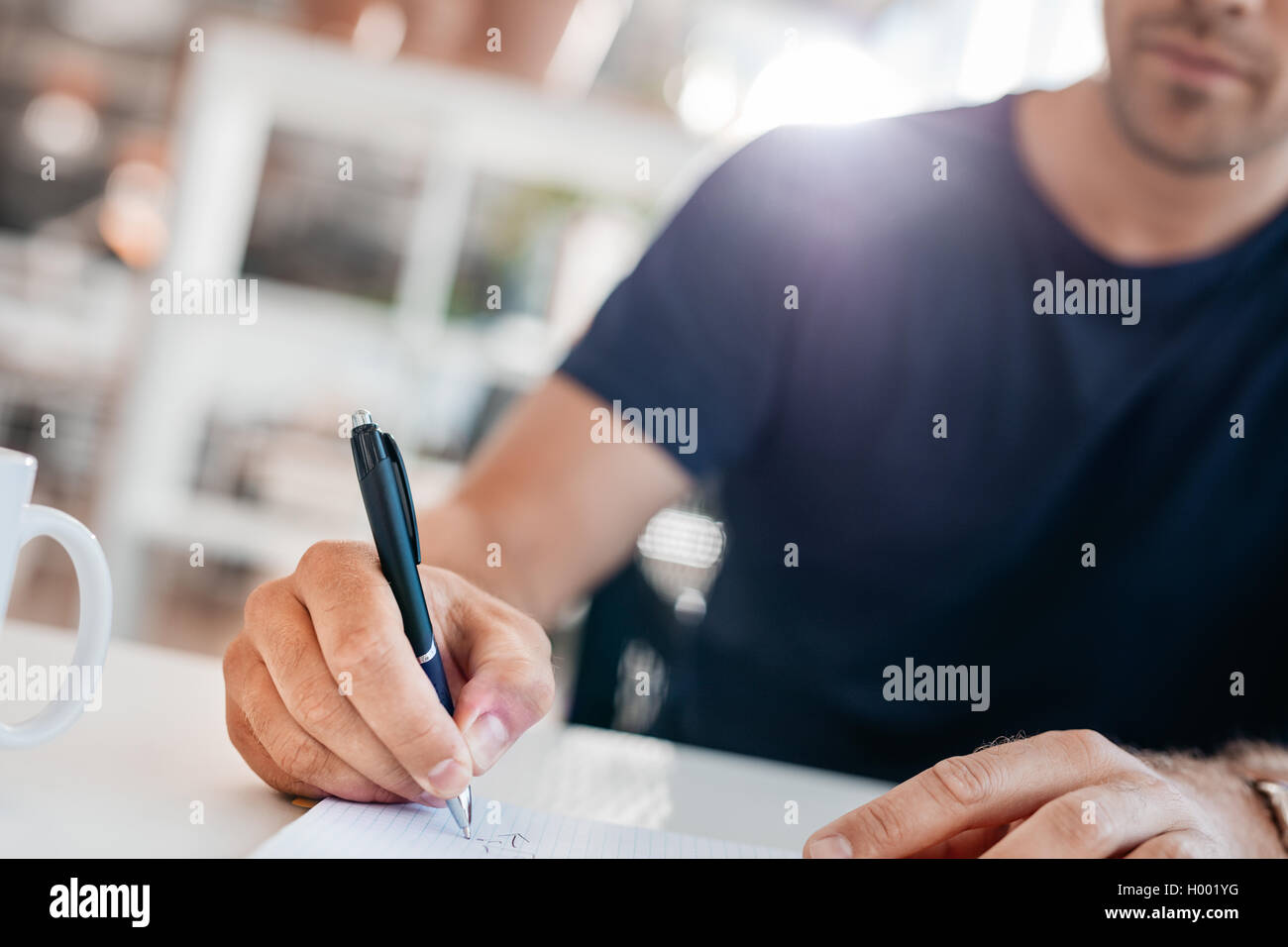 Nahaufnahme des jungen Mannhände in ein Tagebuch zu schreiben. Stift in der Hand der Geschäftsmann im Mittelpunkt. Stockfoto