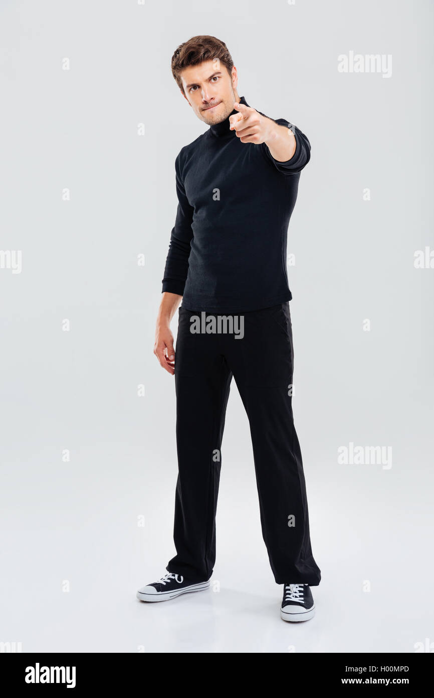 Wütend hübscher junger Mann stehen und auf Sie gerichtet Stockfoto