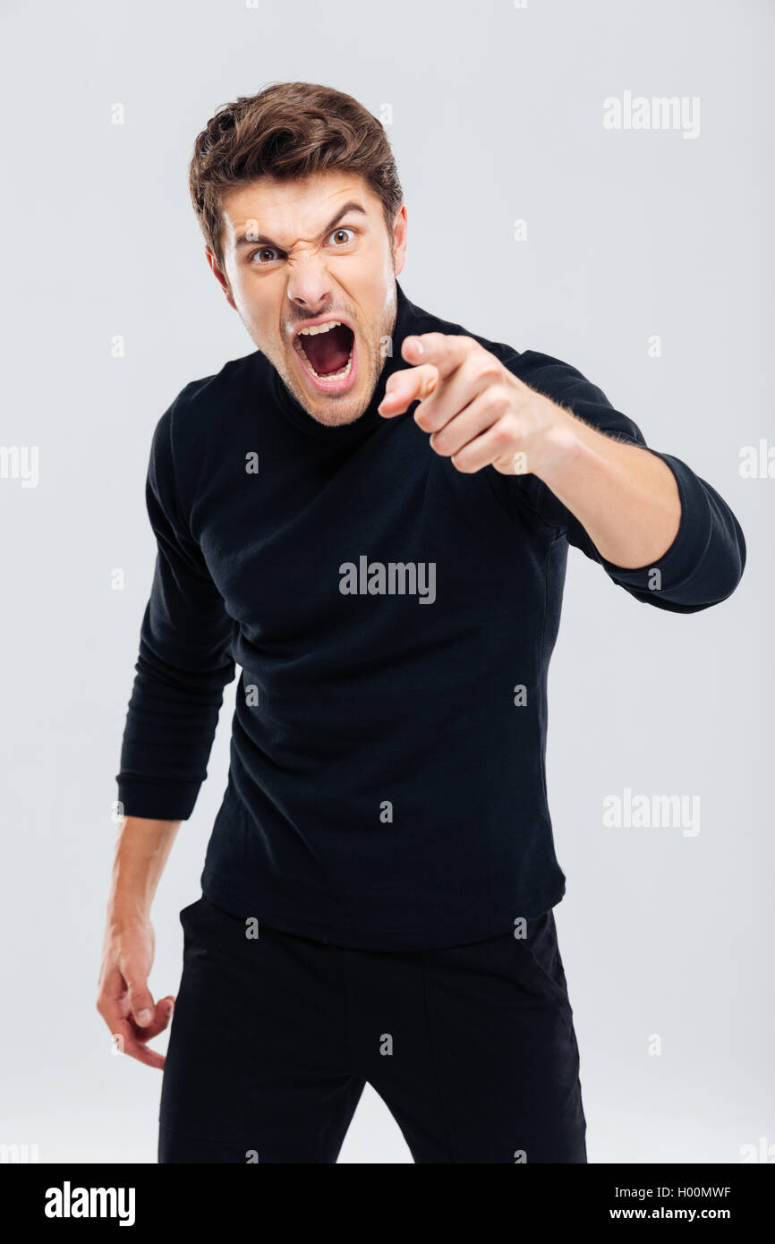 Wahnsinnig wütend junger Mann auf Sie zeigen und schreien Stockfoto