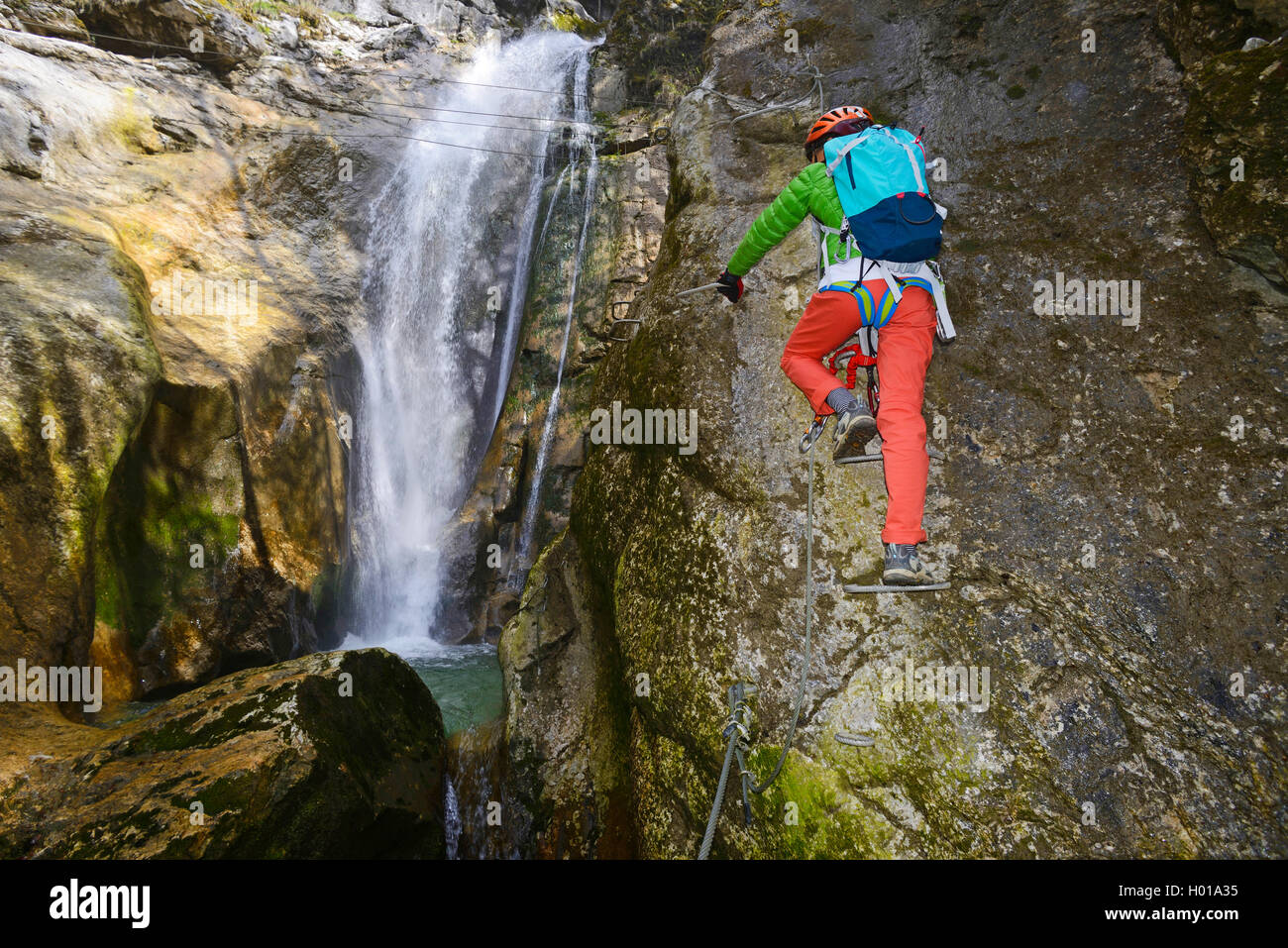 Kletterer am Wasserfall der Normlichtarten, Via Ferrata de Bellevaux, Frankreich, Haute-Savoie Stockfoto