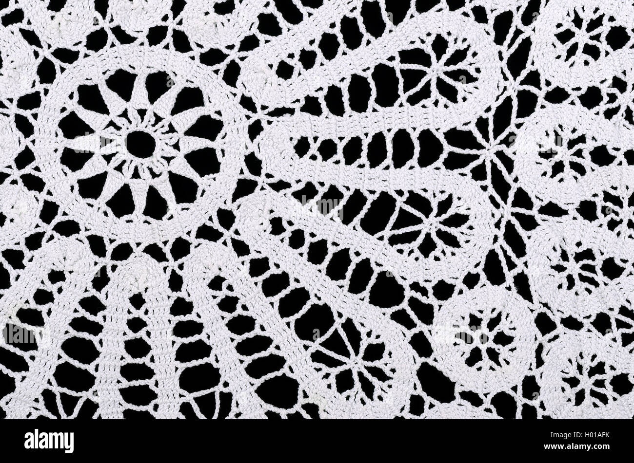 Stern und Kreise in eine weiße gehäkelte Deckchen. Häkeln ist ein Prozess der Schaffung Stoff durch Verzahnung Schleifen des Garns. Stockfoto