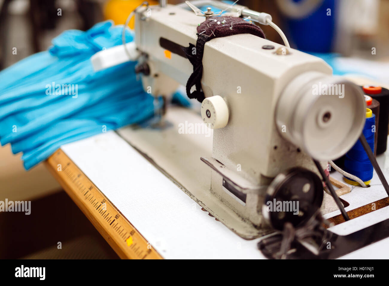 Industrienähmaschine mit Textil auf Schreibtisch Stockfoto