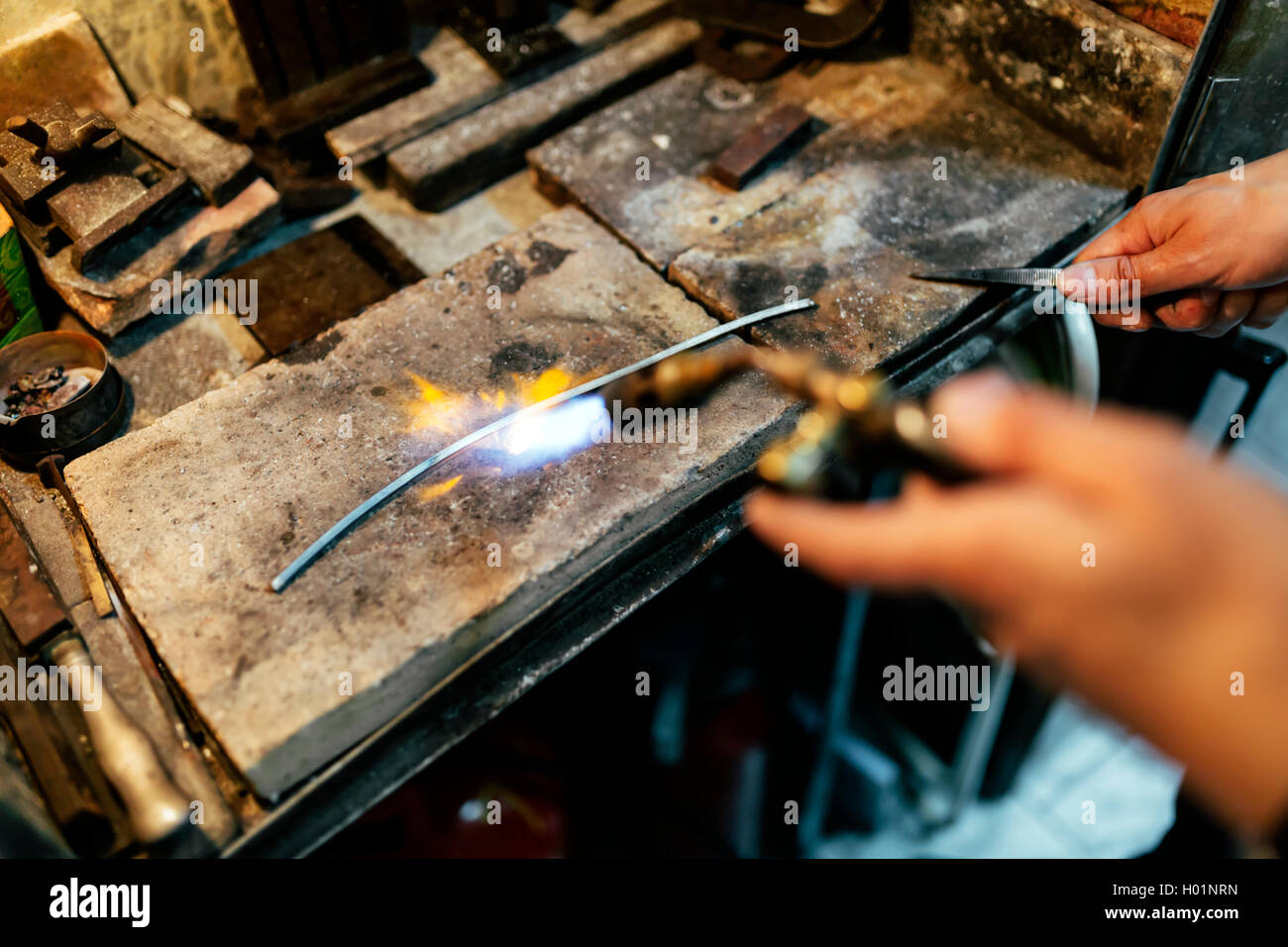 Juwelier Verarbeitung Metallstange durch Erwärmen Stockfoto