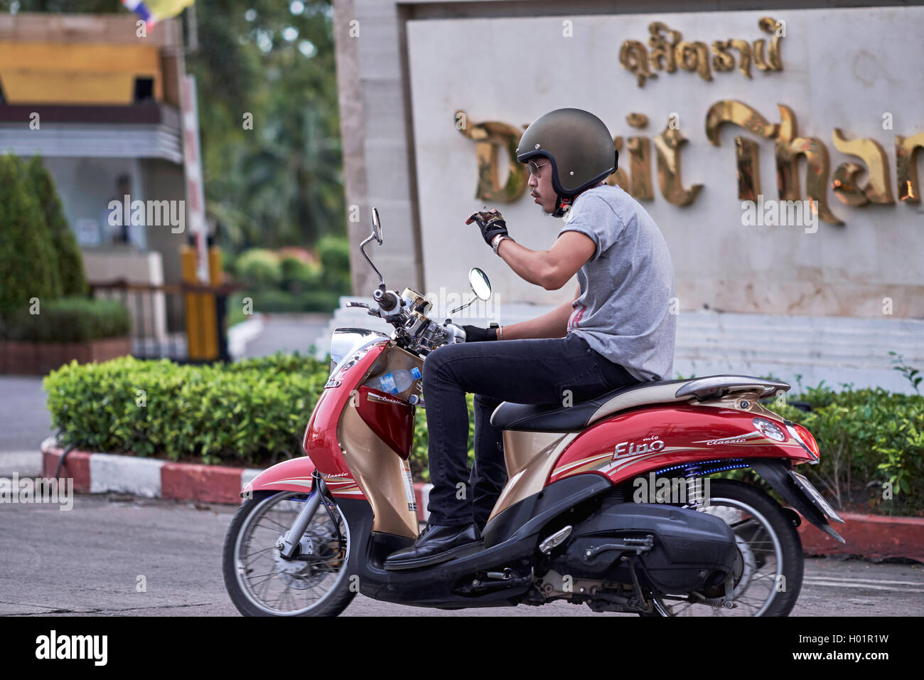 Thailand-Jugend eine Zigarette raucht, während ein Motorrad zu fahren. S. E. Asien Stockfoto