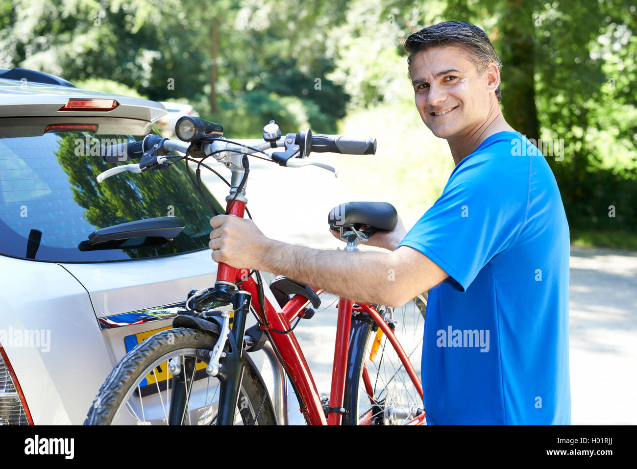 Reife Männchen Radfahrer nehmen Mountainbike von Rack auf Auto Stockfoto